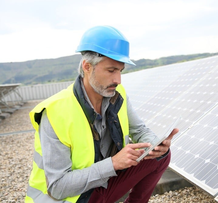 Mature engineer on building roof checking solar panels-1 (1)